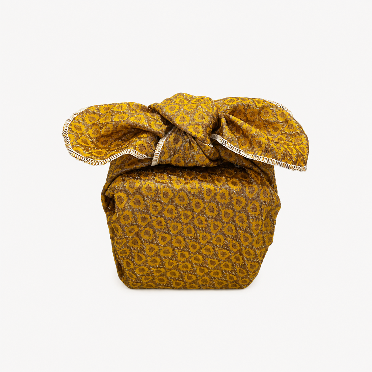 Gift wrapped in yellow and gold embossed polyester fabric with a textured sunburst pattern, full tied folds and white overlocked edging