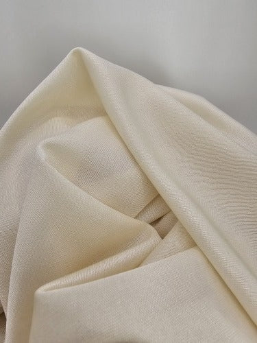 Draped cream polyester fabric showing its lightweight texture, gentle sheen and slightly open weave