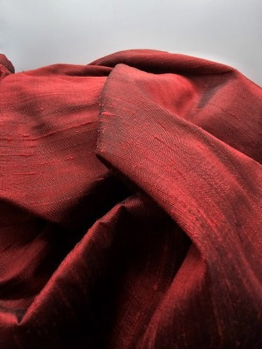 Close-up of Ruby Sheen red raw silk showing its natural textured grain and subtle sheen