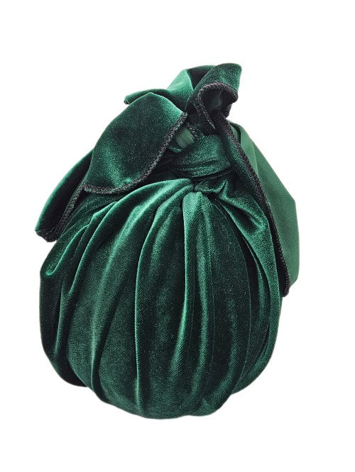 Rectangular gift wrapped in deep green velour fabric, tied at the top with soft draped ends and a black overlocked edge