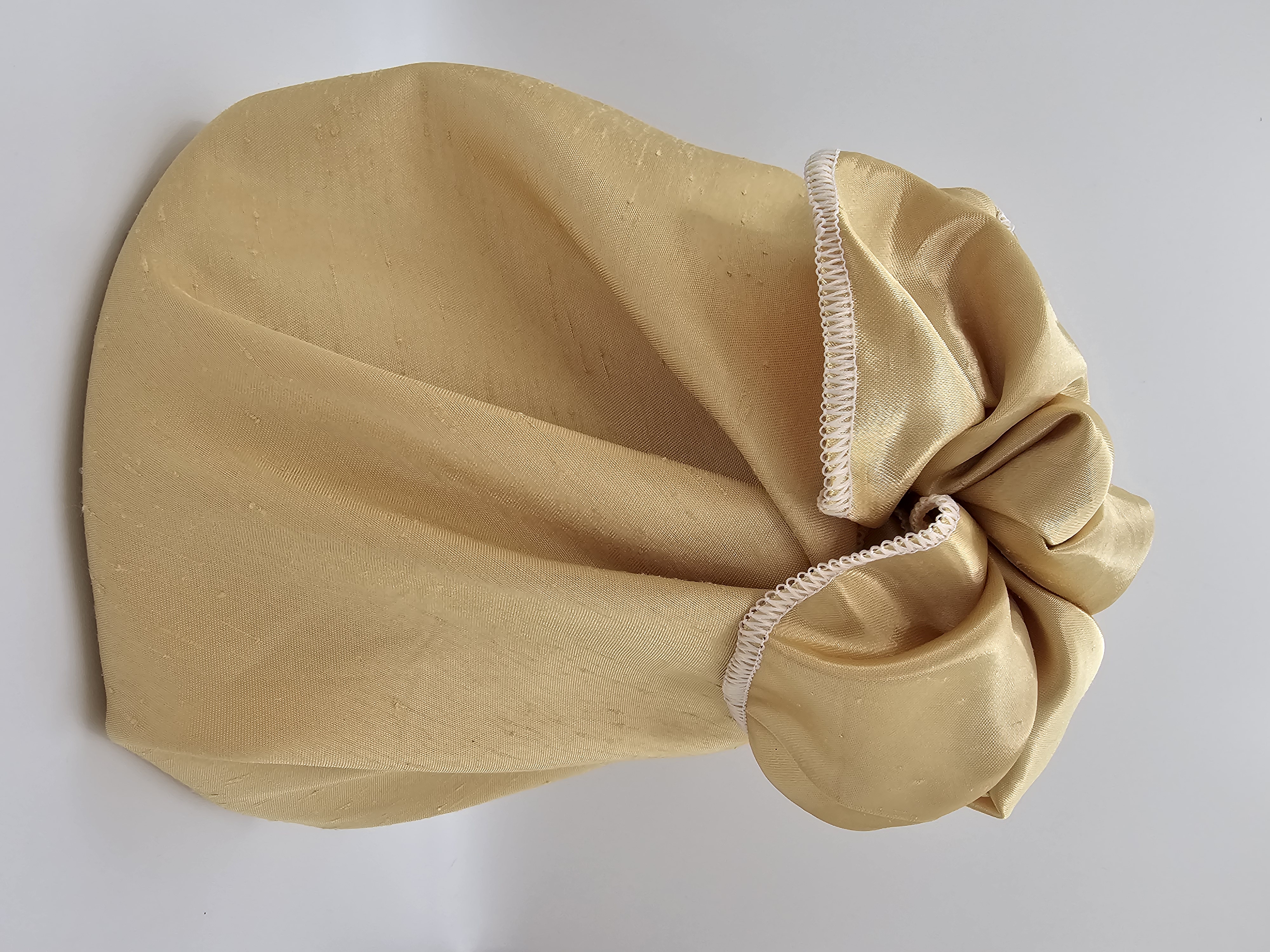 Jug_wrapped_in_golden_coloured_fabric_gift_wrapping_with_a_fancy_bow