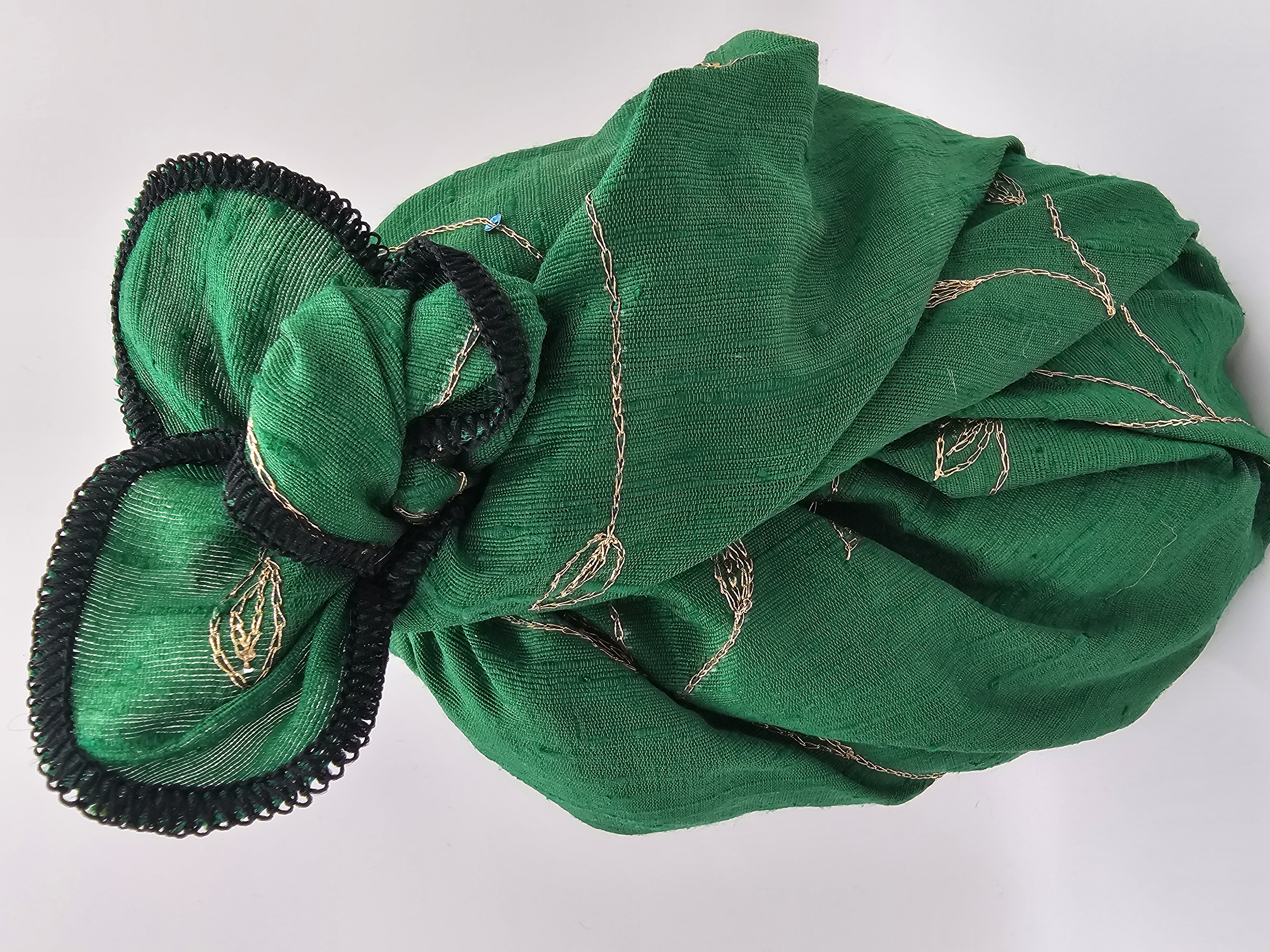 Green_christmas_look_gift_wrapping_fabric_with_golden_embroidery_tied_with_a_fancy_bow_image