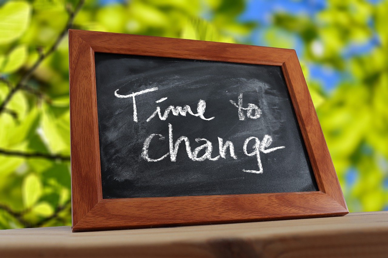 An image of a chalkboard in a wooden frame with time to change written across it in white chalk