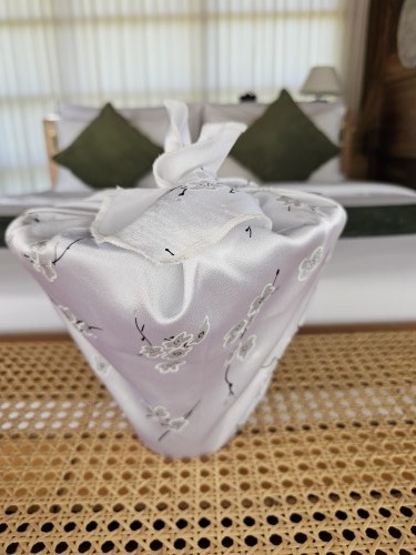 Empty_plant_pot_wrapped_in_white_floral_fabric_gift_wrapping_for_decor
