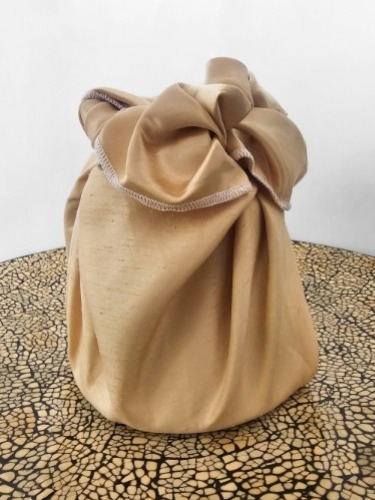 Gold_coloured_fabric_wrapping_a_gift_with_an_elaborate_knot