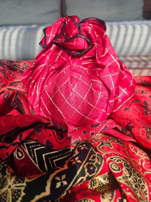 Red_with_gold_lattice_pattern_fabric_gift_wrapping_tied_around_a_round_object
